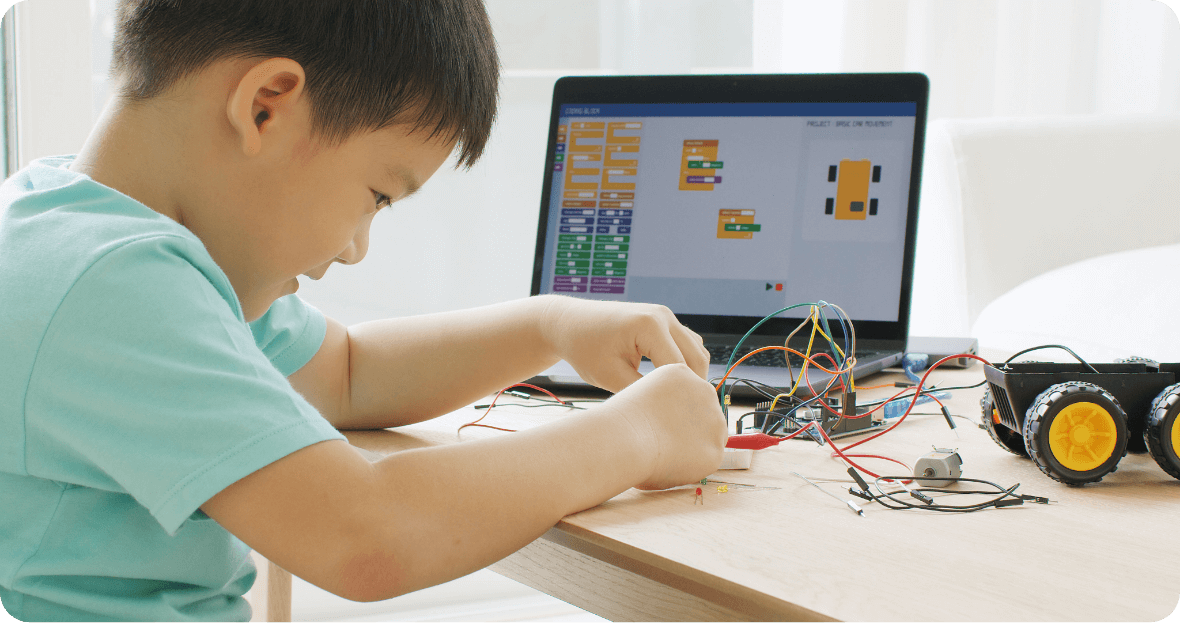 こどもがプログラミングで自動車の工作をしている